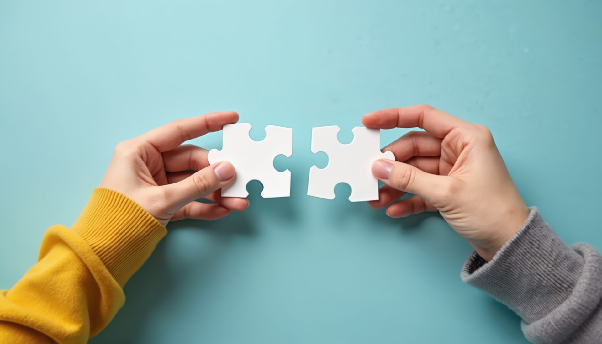 Two hands putting together puzzle pieces cooperation, unity. Solving jigsaw puzzle as concept of partnership, connection. Teamwork, collaboration in business strategy metaphor, find solution.