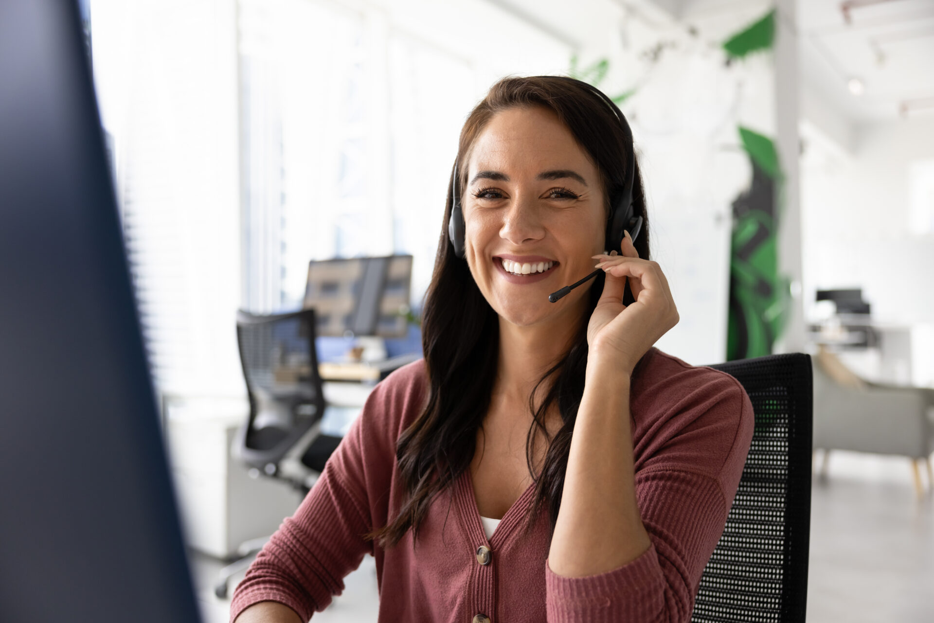 Happy customer contact center employee posing at workplace
